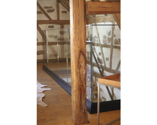 Innenansicht eines Raumes mit Glasgeländer und Holzbalken