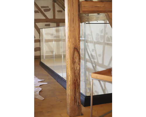 Innenaufnahme eines Hauses mit einem hölzernen Tragbalken und einer Glasbalustrade