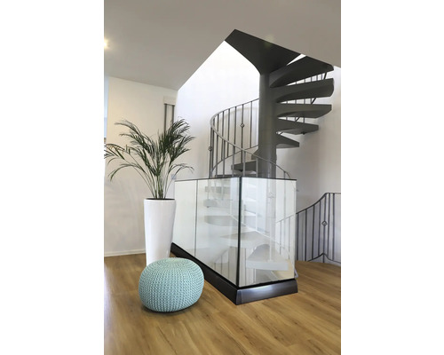 Szene mit Wendeltreppe, Topfpflanze und Sitzpouf in einem hellen Raum