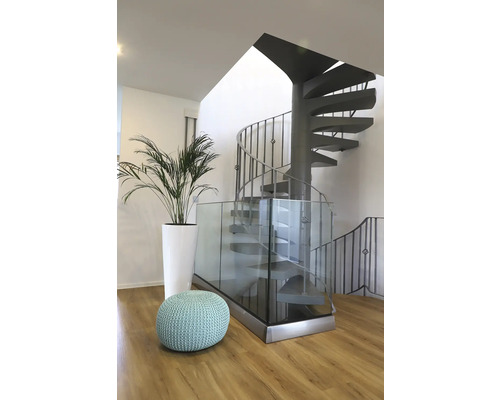 Innenaufnahme mit Wendeltreppe, Glasgeländer, Pflanze und Sitzhocker