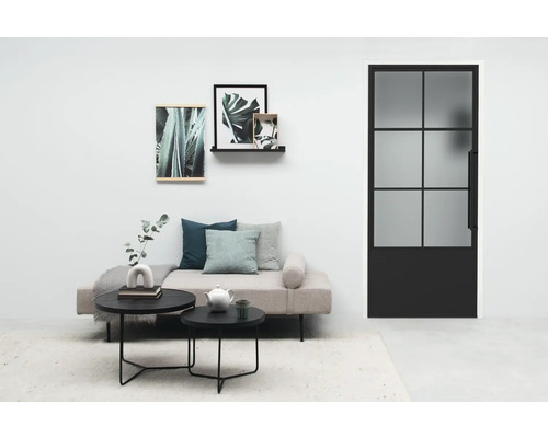 Wohnzimmer mit Couch, Tisch, Bildern und Glastür mit Stahlrahmen