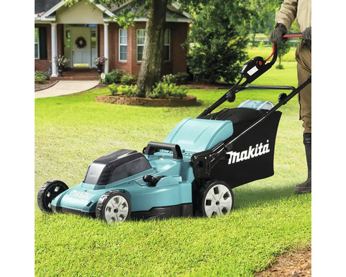 Aufsitzrasenmäher von Makita im Einsatz auf einem Rasen vor einem Haus.