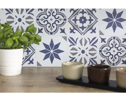 Dekorative Fliesenwand mit floralem Muster und Pflanze im Topf
