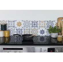 Küchenszene mit Fliesenwand in floralem Design, Kochfeld und Küchenutensilien.