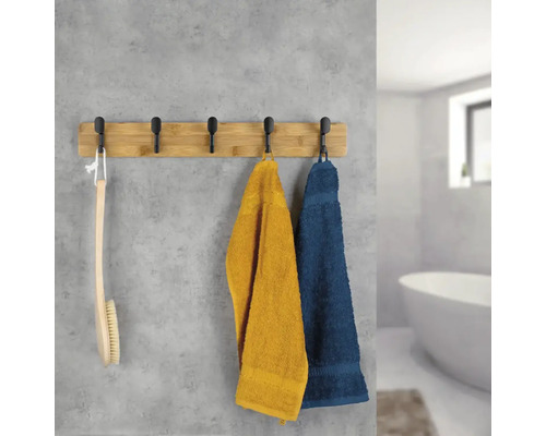 Handtuchhalter mit Handtüchern und Badebürste im Badezimmer