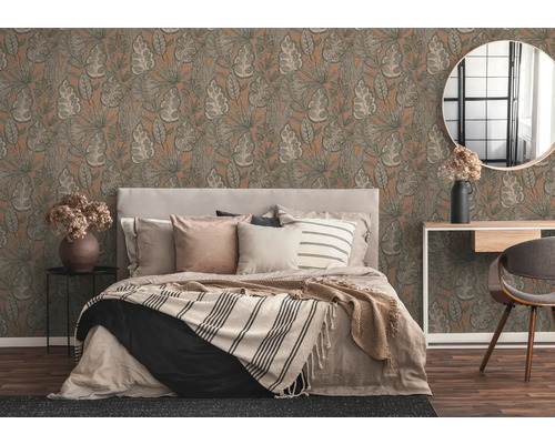 Schlafzimmer mit Bett vor gemusterter Tapete mit Blättern