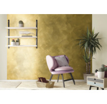 Dekoratives Wohnzimmer mit goldfarbener Wand, Sessel und Regal