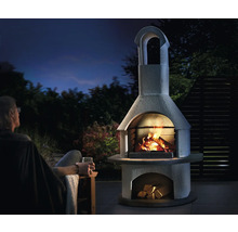 Außenkamin aus Stein mit Feuer und Holz unter freiem Himmel
