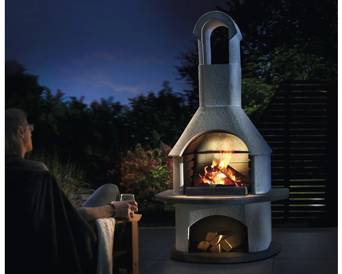 Außenkamin aus Stein mit Feuer und Holz unter freiem Himmel