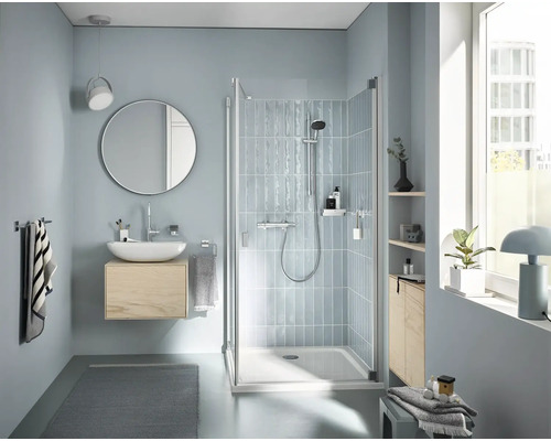 Badezimmer mit Dusche, Waschtisch und Spiegel für eine helle und freundliche Atmosphäre