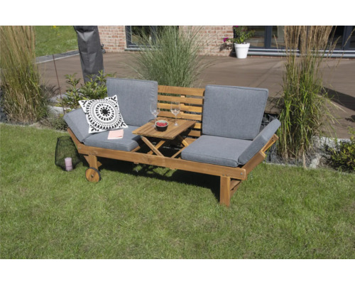 Gartenbank aus Holz mit grauen Auflagen und integriertem Tisch auf einer Rasenfläche
