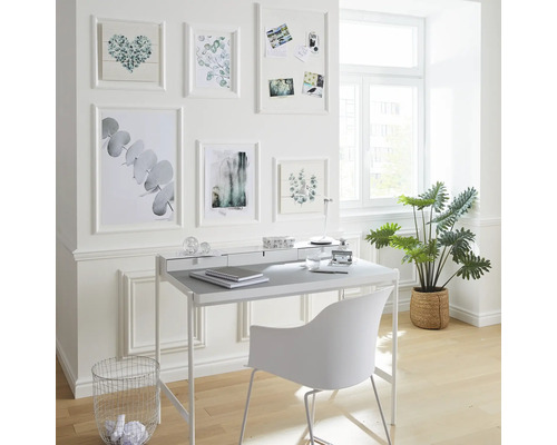 Arbeitszimmer mit Schreibtisch, Stuhl, Zimmerpflanze und Wanddekoration