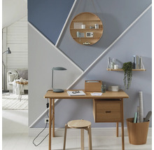 Büro mit Schreibtisch, Stuhl und geometrisch gestalteter Wand