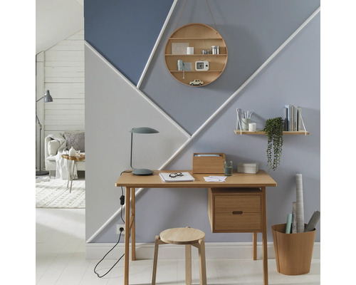 Büro mit Schreibtisch, Stuhl und geometrisch gestalteter Wand