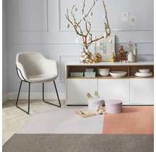 Dekoratives Wohnzimmer mit Sessel, Kommode und Teppich in harmonischen Farben
