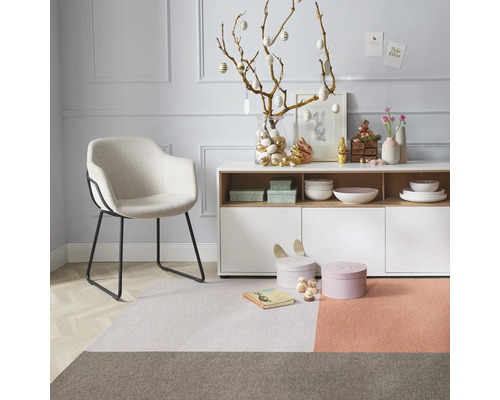 Wohnzimmer mit Sessel, Teppich, Kommode und Osterdekoration