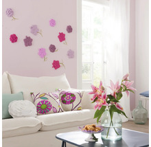 Wohnzimmer mit weißem Sofa, Zierkissen und Wanddekoration mit Blumenmotiven
