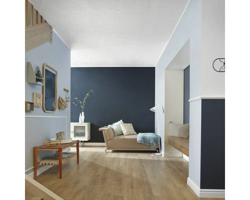 Wohnraum mit Sofa, Tisch, Treppe und Wanddekoration