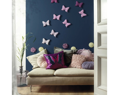 Dekoratives Wohnzimmer mit Sofa, Kissen und Wanddekoration mit Schmetterlingsmotiv