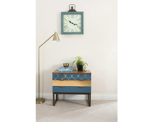 Dekorative Szene mit einem Nachttisch mit drei Schubladen, einer Stehlampe und einer Wanduhr.