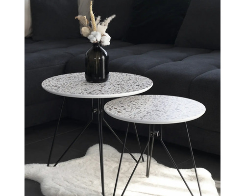 Zwei runde Beistelltische mit Terrazzo-Muster auf einem Teppich
