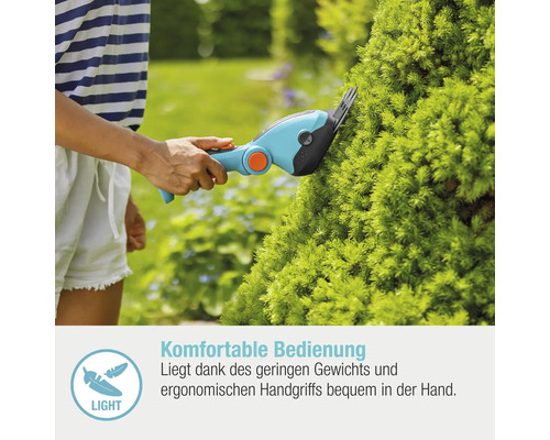 Eine Person schneidet eine grüne Pflanze mit einer Akku-Gartenschere