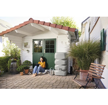 Gartenansicht mit Zisterne, Frau mit Tablet und Gartenhaus