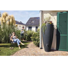 Szene im Garten mit Regentonne, Mann beim Gießen und Frau im Liegestuhl