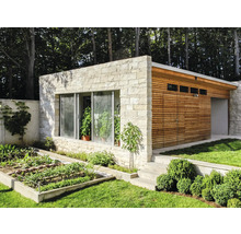 Außenansicht eines modernen Gartenhauses mit Steinfassade, Holzverkleidung und Gemüsebeet