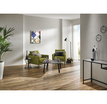 Heller Wohnraum mit zwei Sesseln, einem Couchtisch, einer Stehlampe, einem Sideboard und Holzboden