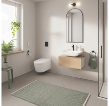 Modernes Badezimmer mit Toilette, Waschtisch, Spiegel und grünen Akzenten