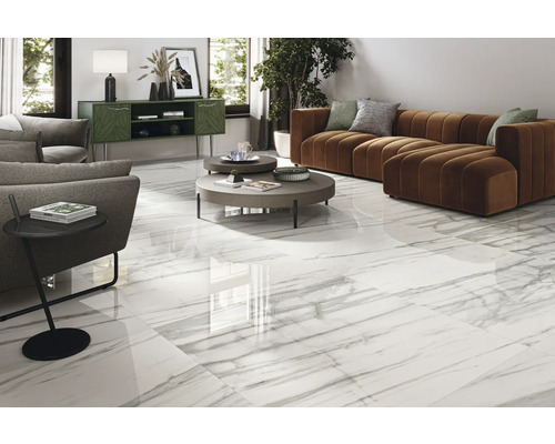 Helles Wohnzimmer mit weißen Fliesen in Marmoroptik, Sofa und Beistelltisch.