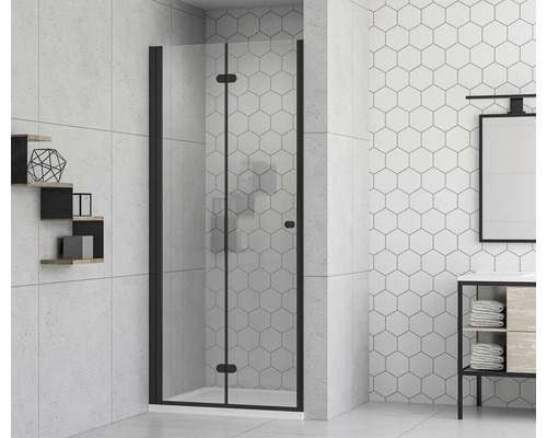 Badezimmer mit Duschkabine mit Falttür und schwarzem Rahmen vor sechseckigen Fliesen.