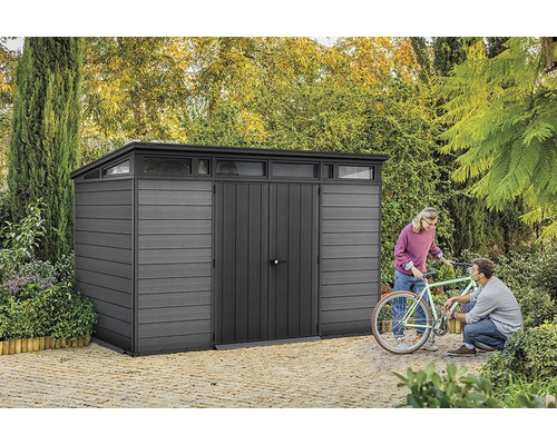 Grauer Geräteschuppen mit Oberlicht und zwei Personen, die ein Fahrrad reparieren