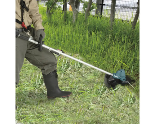Eine Person benutzt einen Akku-Rasentrimmer von Makita im Garten.