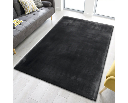 Rechteckiger, dunkler Teppich im Wohnzimmer neben einem Sofa