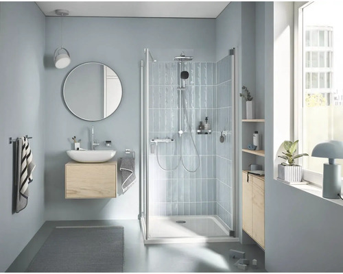 Helles Badezimmer mit Dusche, Waschbecken, Spiegel und Fenster für eine freundliche Atmosphäre