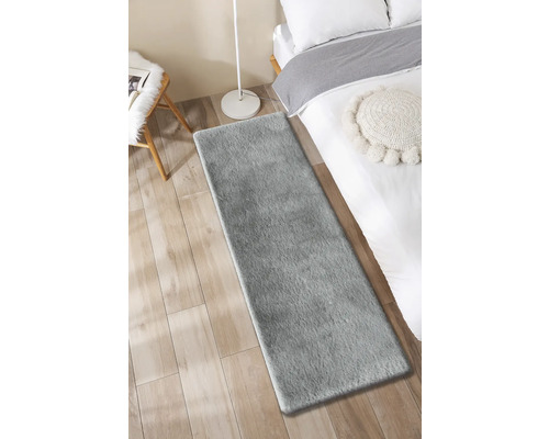 Grauer Teppichläufer im Schlafzimmer auf Holzboden