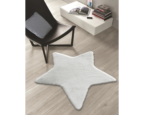 Sternförmiger Teppich auf einem Holzboden neben einem Sessel und einem Tisch