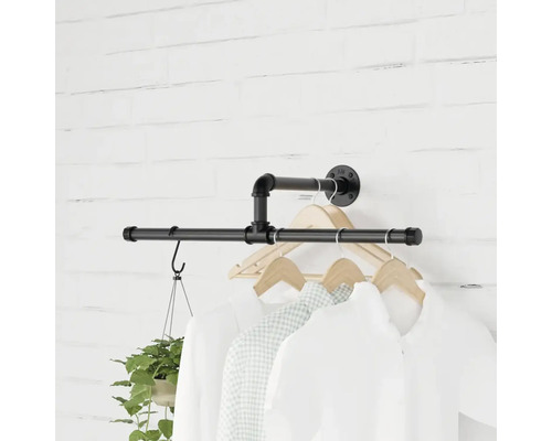 Wandgarderobe aus Rohren mit Kleidung und Topfpflanze