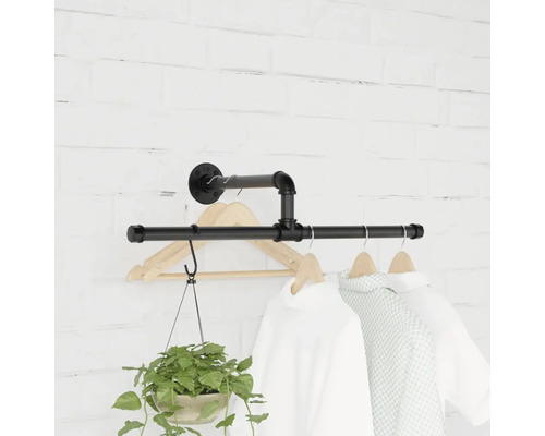 Wandgarderobe aus Rohren mit Kleidung und Topfpflanze