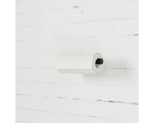 Küchenrollenhalter mit Papierrolle an einer Ziegelwand