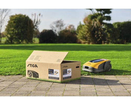 Stiga Logo auf Karton mit Rasenmähroboter im Garten