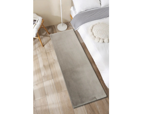 Schlafzimmer mit Teppich, Bett, Lampe und Stuhl