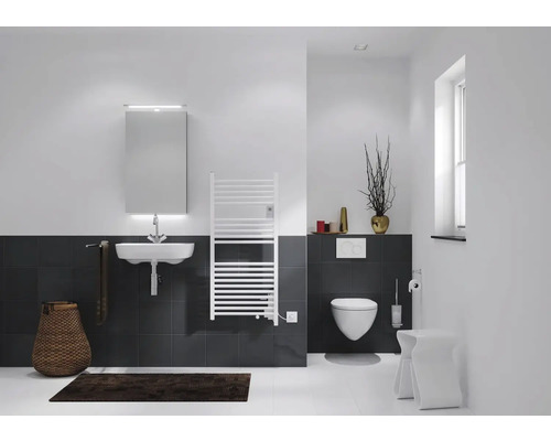 Badezimmer mit Waschbecken, Spiegel, Heizkörper und Toilette.