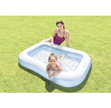 Aufblasbarer Pool mit zwei Personen auf einer Rasenfläche.