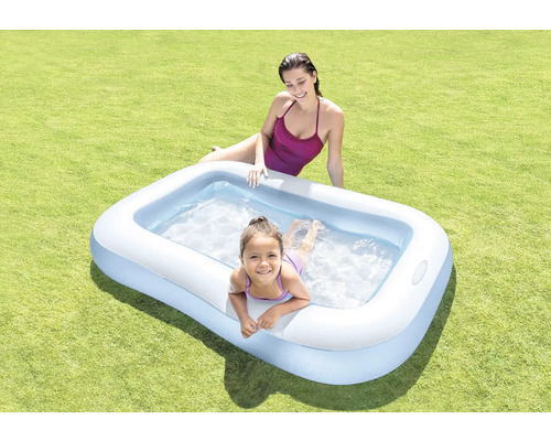Aufblasbarer Pool mit zwei Personen auf einer Rasenfläche.