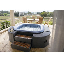 Aufblasbarer Whirlpool mit Umrandung und Treppe auf einer Terrasse mit Gartengarnitur