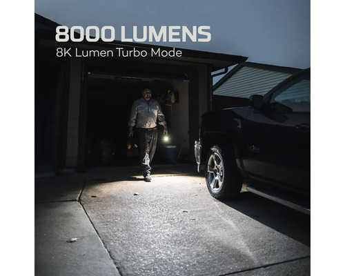 Szene mit einer Taschenlampe, die 8000 Lumen im Turbo-Modus leuchtet. Im Hintergrund ist eine Person vor einer Garage und einem Auto zu sehen.