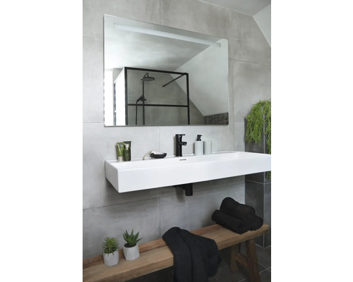 Modernes Badezimmer mit rechteckigem Spiegel, Aufsatzwaschbecken, Armatur, Handtüchern und Holzbank.